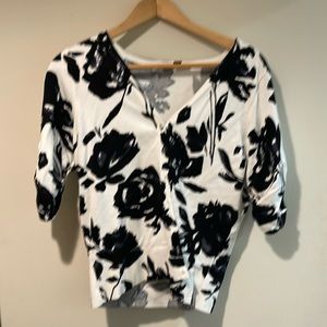 A large, woman Inc, black, and white sweater with rhinestone buttons